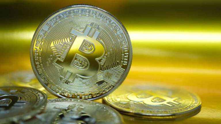Mince bitcoinu na zlatém pozadí.